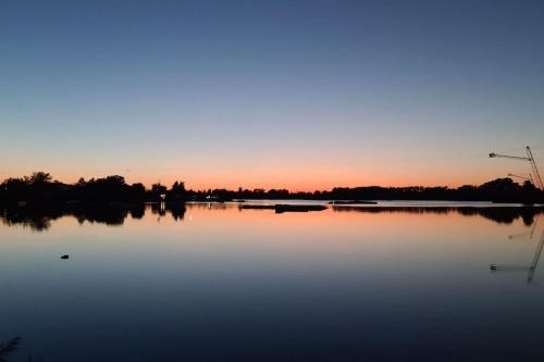 a large body of water with a sunset in the background at Wake domek Green House Januszkowice in Januszkowice