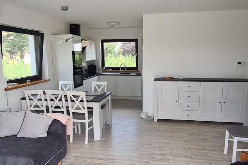 a living room with a couch and a table and a kitchen at Wake domek Green House Januszkowice in Januszkowice