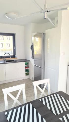 a kitchen with two white chairs and a refrigerator at Wake domek Green House Januszkowice in Januszkowice