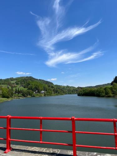 a red bench in front of a lake at Apartman Eden in Rožnov pod Radhoštěm