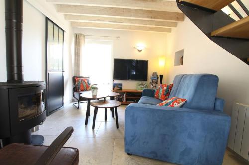 Le Vast的住宿－Gîte Au fil de l'eau，客厅设有蓝色的沙发和壁炉