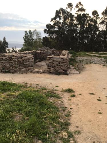 a stone wall sitting on top of a field at Complexo Alameda in Viveiro