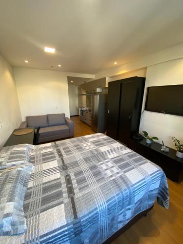 1 dormitorio grande con 1 cama y 1 sofá en Flat Apart America Campos, en Campos dos Goytacazes