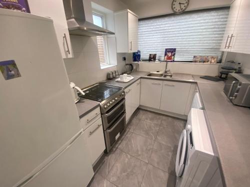 eine Küche mit einer Spüle und einem Herd Top-Backofen in der Unterkunft Bramcote 3 bedroom house in Bramcote