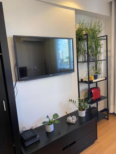 a living room with a large flat screen tv on a wall at Flat Apart America Campos in Campos dos Goytacazes
