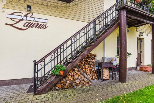 a pile of fire wood next to a staircase at Vila Laurus in Palanga