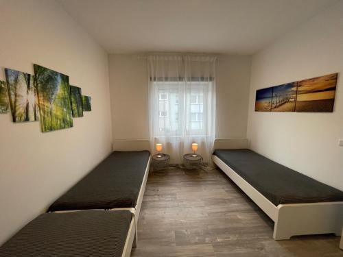 dwa łóżka w pokoju z oknem w obiekcie Heimathafen Wanne w mieście Herne