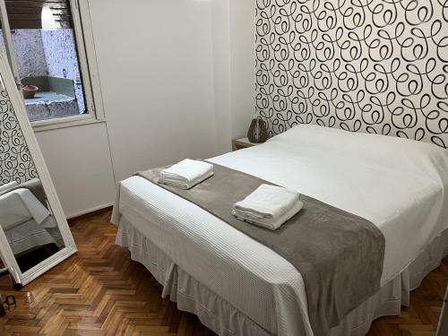 1 dormitorio con 1 cama con 2 toallas en Cálido y Amplio Apartamento en Belgrano en Buenos Aires