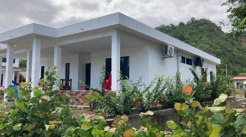 una casa blanca con algunas plantas delante de ella en Estancias De Olon, en Olón