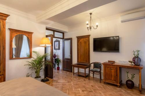 a bedroom with a television on the wall and a desk at Clucerului Arc De Triomphe in Bucharest