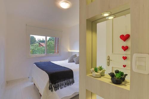 um quarto com uma cama e um espelho com corações na parede em Conforto perto do centro em Gramado