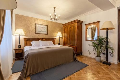Un dormitorio con una cama grande y una lámpara de araña. en Clucerului Arc De Triomphe en Bucarest