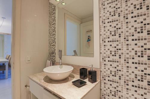 uma casa de banho com um lavatório e um espelho em Conforto perto do centro em Gramado