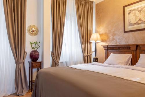 a bedroom with a bed and a window with curtains at Clucerului Arc De Triomphe in Bucharest