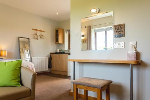 een woonkamer met een spiegel en een stoel bij Wick House in Taunton