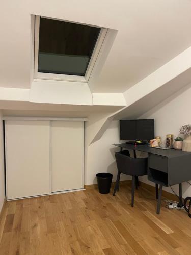 a room with a desk and a television in a ceiling at Chambre à Saint-Mandé entièrement refait à neuf in Saint-Mandé