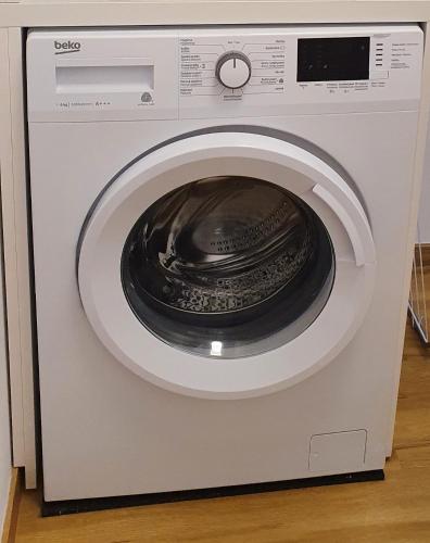 a washing machine with its door open in a kitchen at Apartman Eden in Rožnov pod Radhoštěm