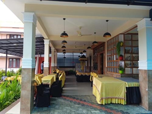 a restaurant with yellow tables and chairs at Meghdoot river resort in Ernakulam