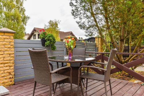 a patio with a table and chairs on a deck at Vila Laurus in Palanga