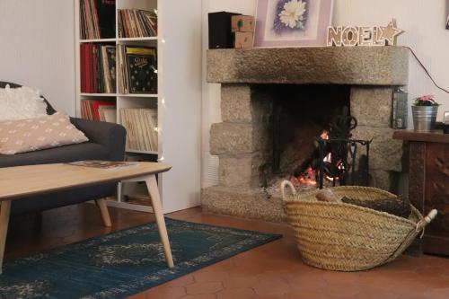 a living room with a fireplace with a couch and a basket at De Rafael Cabañas de Madera in Venturada