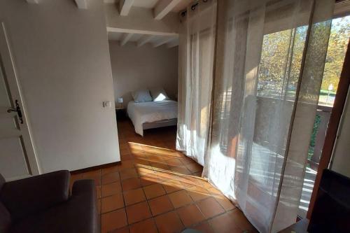 a room with a bedroom with a bed and a window at T1 Proche Annecy in Épagny