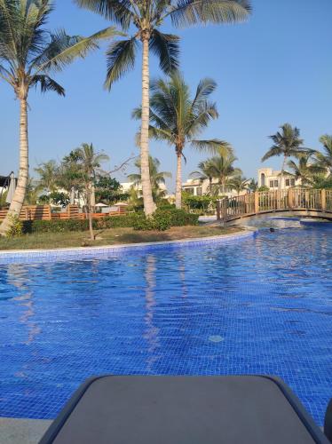 a swimming pool with palm trees in the background at Segal Salalah-Forest Island-Hawana in Salalah