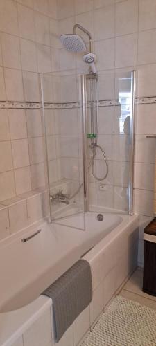 a white bathroom with a tub with a shower at Beach Hive 1 in Swakopmund