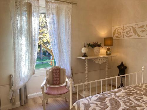 - une chambre avec un lit, une chaise et une fenêtre dans l'établissement MANZONI37, à Novi Ligure
