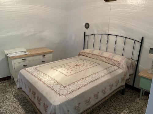 1 dormitorio con cama, mesita de noche y cama sidx sidx sidx sidx sidx en Casa Béjar, Tranquila casa con chimenea, patios, junto a la piscina, en Cañete la Real