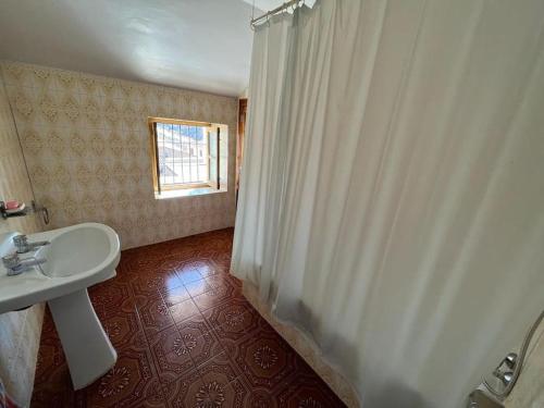 baño con lavabo y cortina de ducha en Casa Béjar, Tranquila casa con chimenea, patios, junto a la piscina, en Cañete la Real