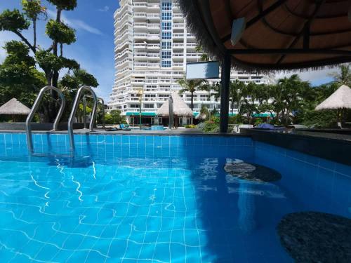 a blue swimming pool with a tall building in the background at Andaman sea view private in Patong Beach
