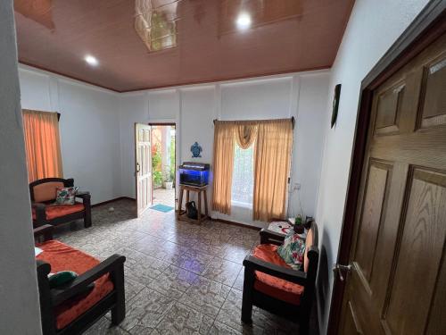 ein Wohnzimmer mit 2 Sofas und einem TV in der Unterkunft Natural Experience House in Tortuguero