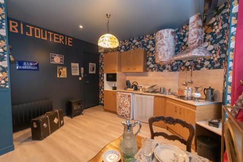 une cuisine avec une table et une salle à manger dans l'établissement Au Gentleman Cambrioleur, à Charleville-Mézières