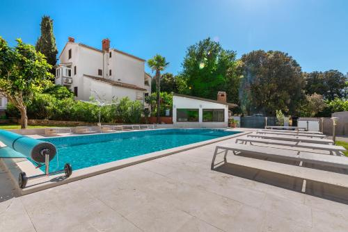 een zwembad voor een huis bij Istrian Tavern next to the Pool in Banjole