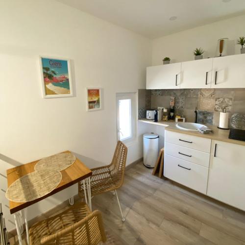 une cuisine avec une table et une salle à manger dans l'établissement Petite maison cosy et moderne avec bain à remous, à Hyères