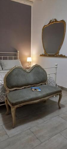 a large bench sitting in a bedroom with a mirror at Loft Ballarò in Palermo