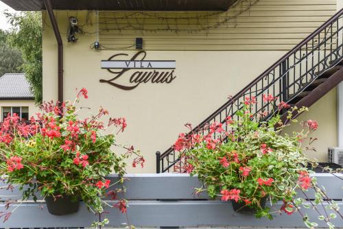 two potted plants on the stairs of a building at Vila Laurus in Palanga