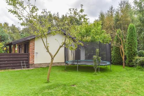 a small house with a trampoline in a yard at Vila Laurus in Palanga