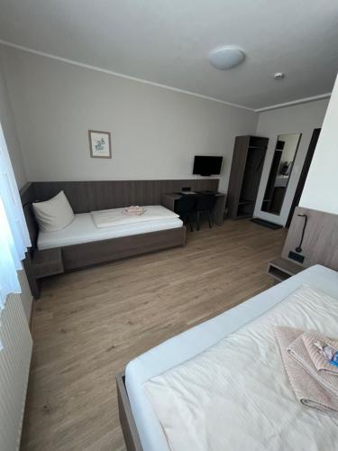 ein Hotelzimmer mit 2 Betten und einem Schreibtisch in der Unterkunft Hotel Stockumer Hof in Werne an der Lippe