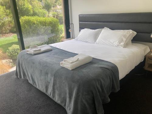 een bed met twee handdoeken bovenop bij Garden Apartment in Queenstown