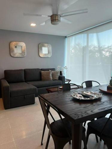 a living room with a table and a couch at Precioso Loft a pie de playa in Nuevo Vallarta