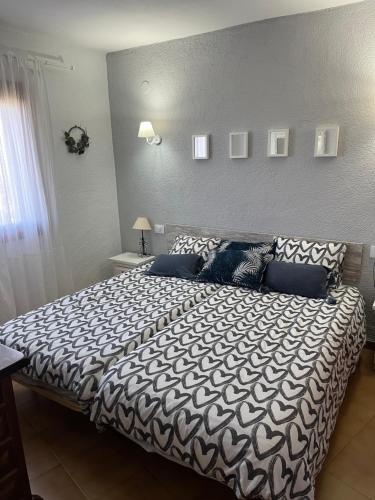 Schlafzimmer mit einem großen Bett mit blauer und weißer Bettwäsche in der Unterkunft Apartamento Urb Oasis Park II Denia, las Marinas in Denia