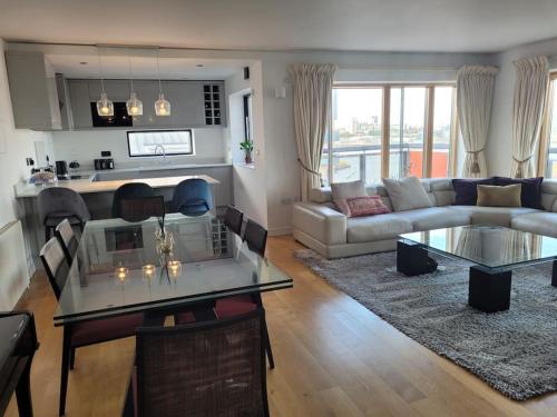 a living room with a couch and a table at Stunning 3 Double Bedroom Apt in Greenwich near O2 in London
