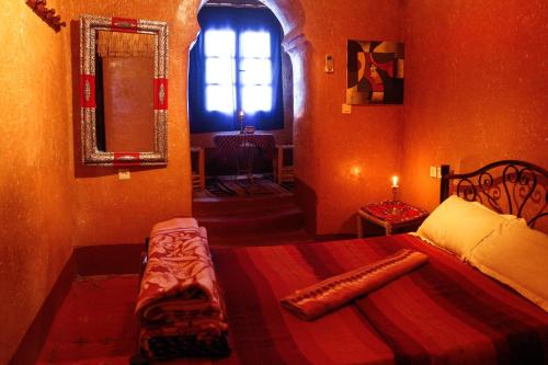 a small bedroom with a bed and a window at La Fibule D'or in Aït Ben Haddou