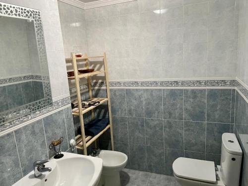 a bathroom with a white toilet and a sink at Edificio La Horteta in La Font D´En Carròs
