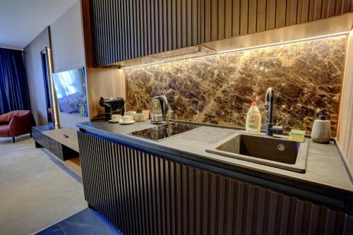 a kitchen with a sink and a living room at Woodside Kopaonik 417-418 in Kopaonik