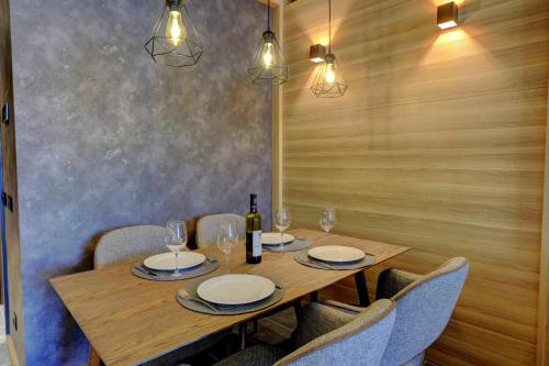 a wooden table with chairs and a bottle of wine at Woodside Kopaonik 417-418 in Kopaonik