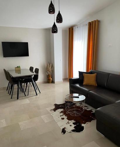a living room with a black couch and a table at Villa Franko Baška Voda in Baška Voda