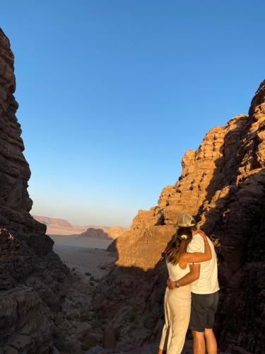 a man and a woman standing in a canyon at Rum Kingdom Camp in Wadi Rum