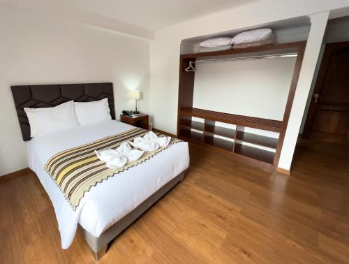 a bedroom with a large bed and a large window at Hotel Andes de Urubamba in Urubamba